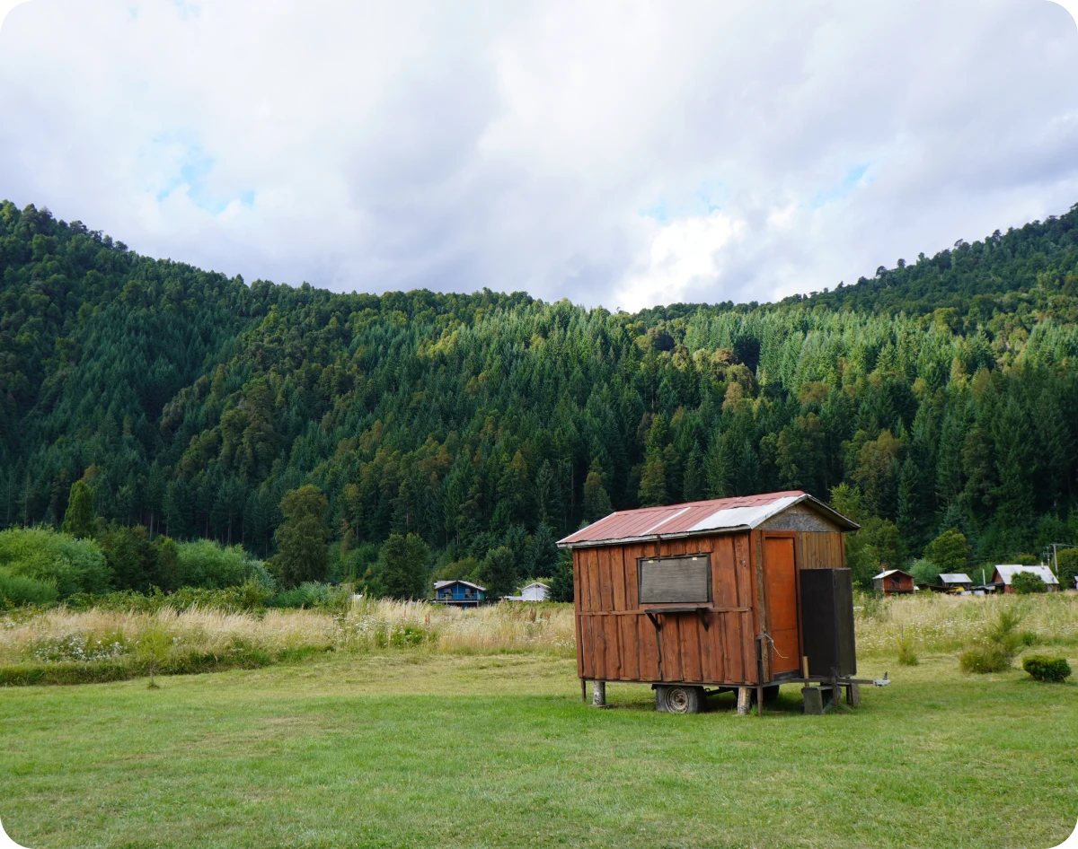 Solitary cabin amidst verdant mountains.